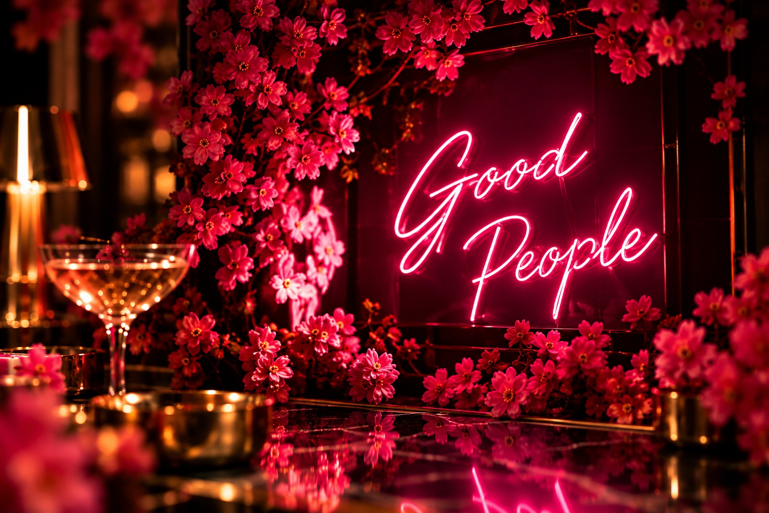 Good People pink neon sign among pink flowers